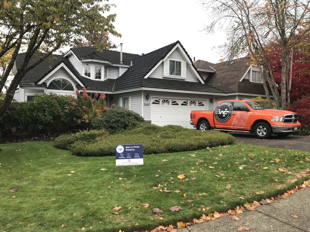 Wonderflow Plumbing Solutions truck parked in front of a residential home with a “Start to Finish Repiping” sign on the lawn.